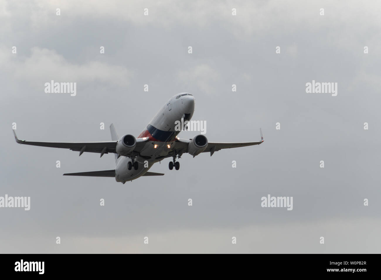 DENPASAR, Bali/Indonesien - Juni 08 2019: Malaysia Airline ist vom internationalen Flughafen Ngurah Rai Bali Landebahn, wenn der Himmel bewölkt ist grau Stockfoto