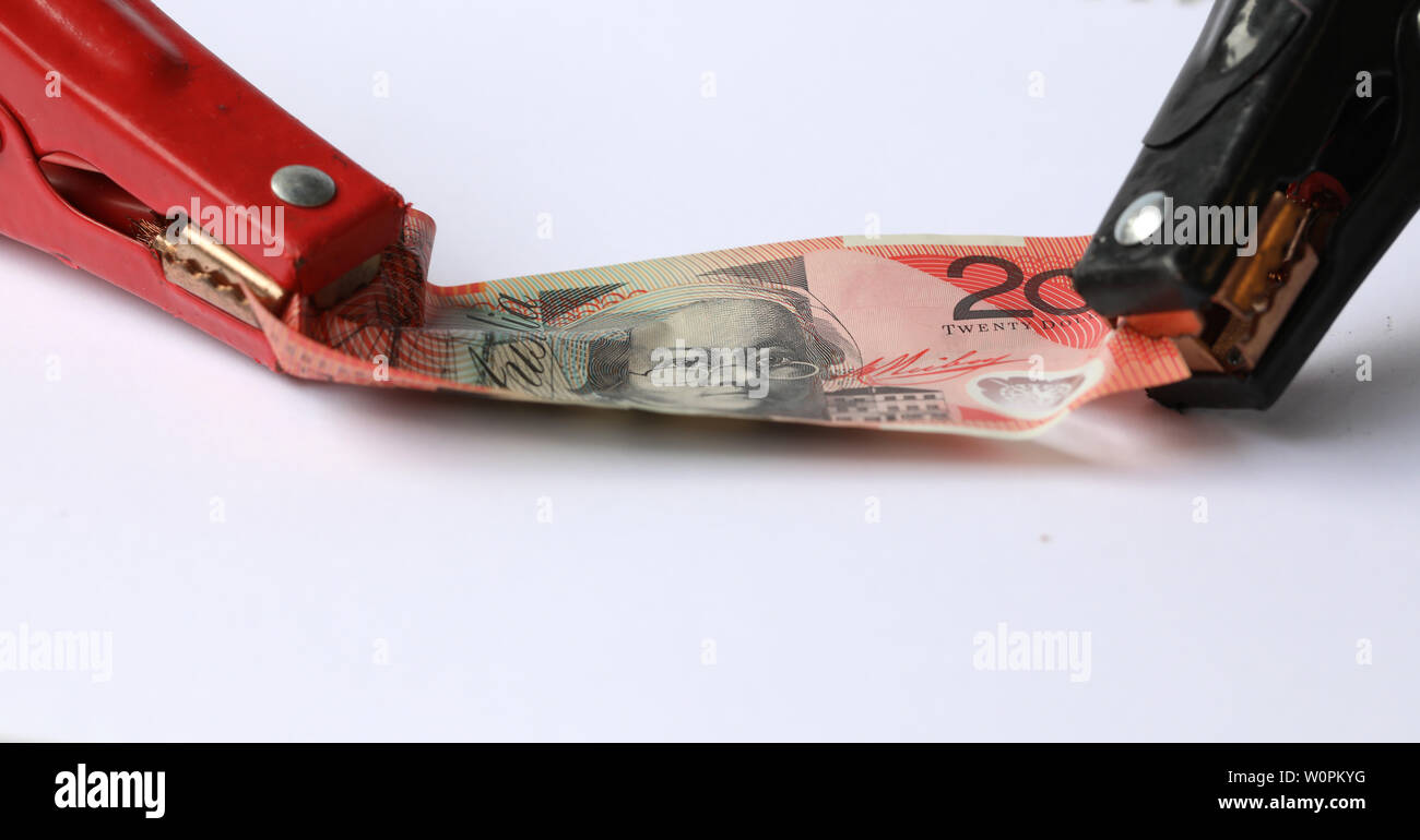 Australische 20 20 Dollar Note durch Überbrückungskabel Schellen gehalten. Kreatives Konzept für Entlasten Geld-, Banken-, Finanz-, Wirtschafts-, Währungs- Schmerz Stockfoto