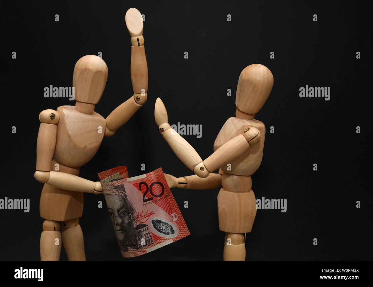 Paar Holz Puppen streiten kämpft über Hypothek Finanzen finanzielle Druck Belastung Härte. Australische zwanzig Dollar Note. Wirtschaftliche Konzept Stockfoto