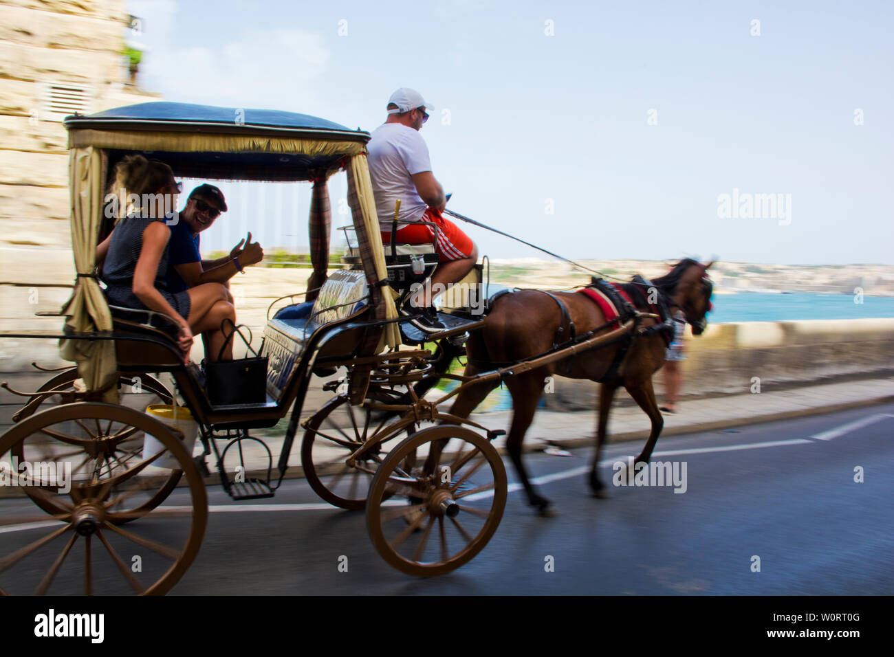 Karozzin Kutsche trägt touristische Paar in Valletta Waterfront Straßen Stockfoto