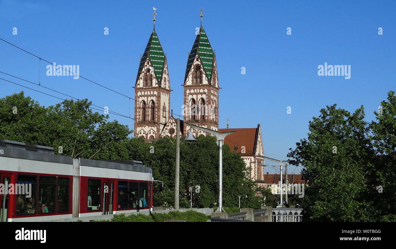 Herz-Jesu-Kirche im Stadtteil Stühlinger, Freiburg, im Vordergrund fährt eine Straßenbahn vorbei Stockfoto