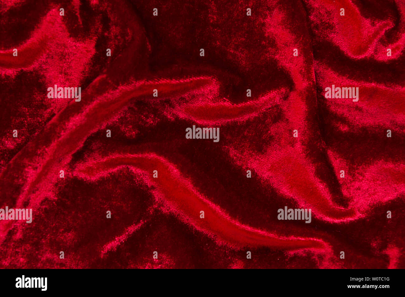 Hintergrund aus dunkelrotem Samt mit faltet. Stockfoto