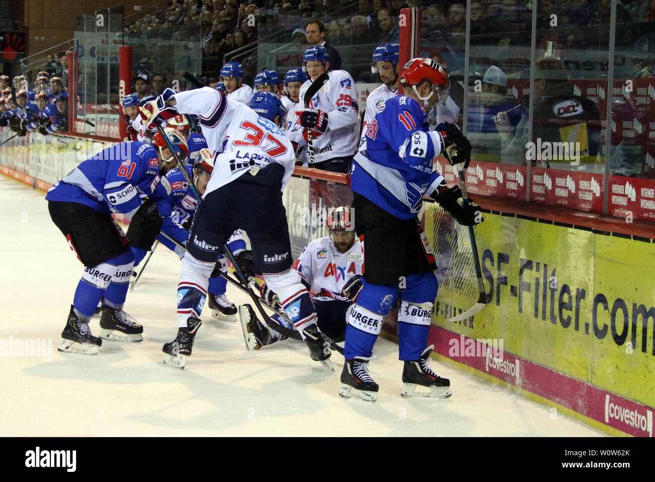 Duell an der Bande, Andrew Desjardins sitzt auf dem Boden, Ville Korhonen (Schwenningen), Mirko Hoefflin (Schwenningen), obenauf, v. li. im Zweikampf, Thomas Larkin, 22. Sptg. DEL 18-19: serc Wildwings vs Adler Mannheim Stockfoto