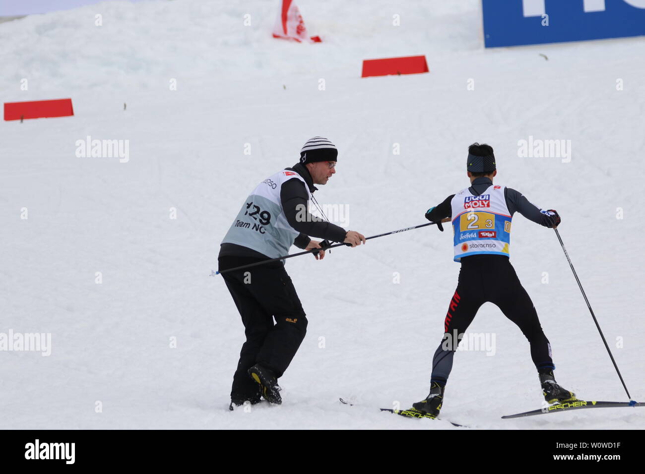 Ein Betreuer reicht Akito Watabe (Japan) einen neuen Lager bei der Team Nordische Kombination, FIS Nordische Ski-WM 2019 in Seefeld Stockfoto