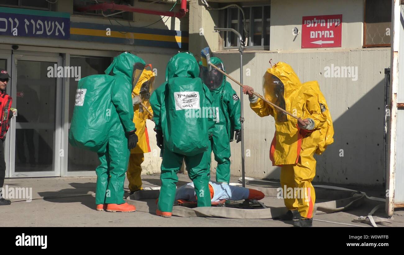Feuerwehrmänner dressing schützende Suiten Reinigung Opfer aus undichten giftig medizinische Gase in Haemek Krankenhaus während bohren. Afula, Israel, 30. Januar 2017 Stockfoto