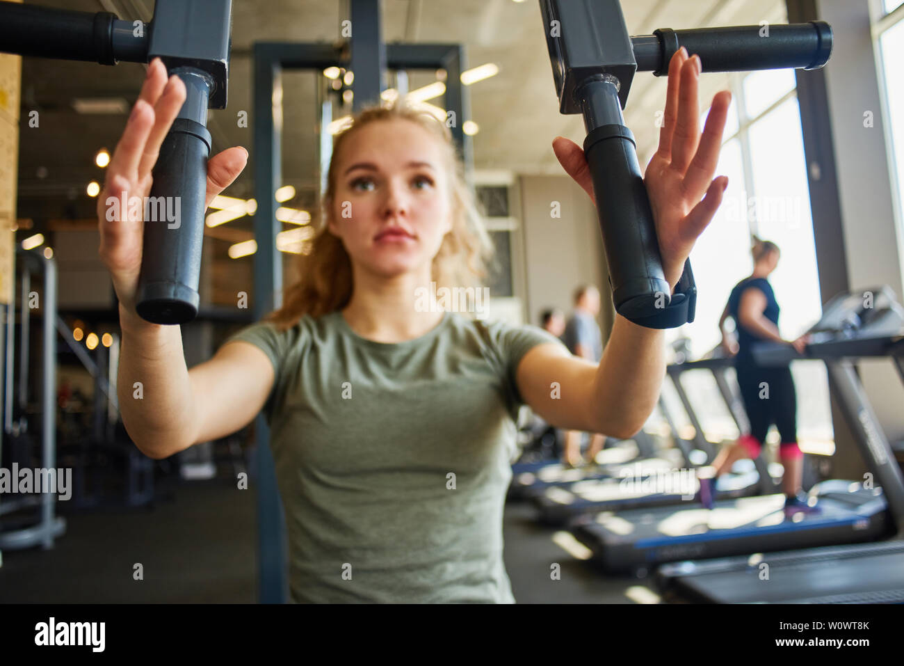 Mädchen in Sportkleidung ist gewichtheben Training für Oberkörper mit Fitnessgeräten. Stockfoto