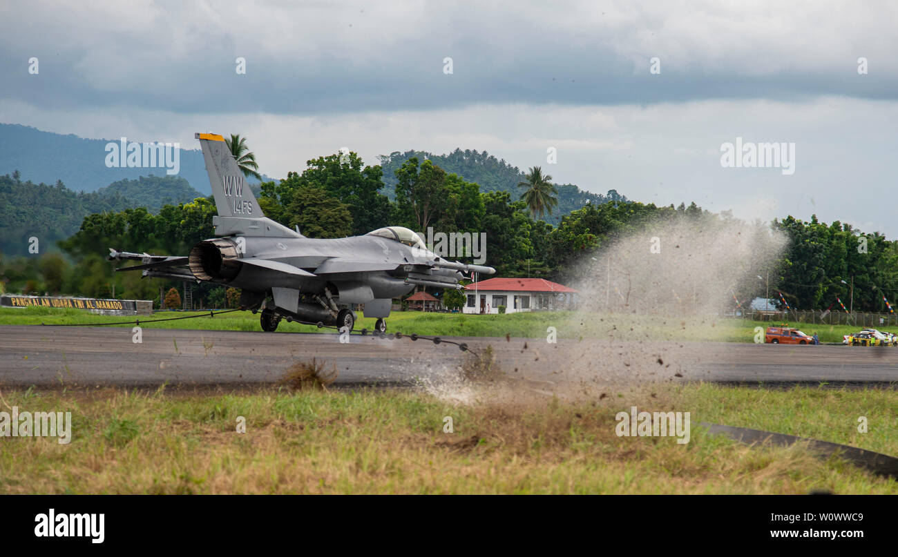 Ein US Air Force F-16 Fighting Falcon aus der 14 Fighter Squadron, Misawa Air Base, Japan, zieht die mobile Flugzeuge Auffangsystem (MAAS) Kabel an der Sam Ratulangi International Airport, Manado, Indonesien, 17. Juni 2019. Die Maas ist ein verfügbarkeitsplan Flugplatz Asset, das ermöglicht die sichere Bereitstellung der Schwanz haken Flugzeuge während eines Fluges Notfall. Es ist portabel und kann in einer Vielzahl von Methoden und auf praktisch jeder Oberfläche Art Abdeckung in eine Vielzahl von Szenarien zur Verfügung zu stellen installiert werden. (U.S. Air Force Foto: Staff Sgt. Melanie A. Hutto) Stockfoto