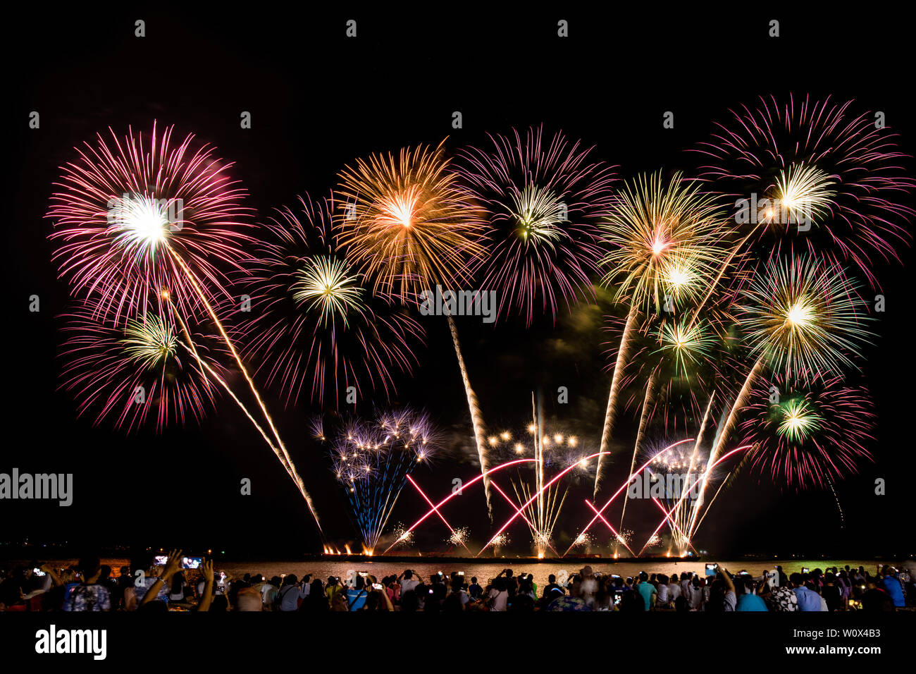 Jubelnde Menge beobachten, bunten Feuerwerk und Feiern am Strand während der Festival Stockfoto