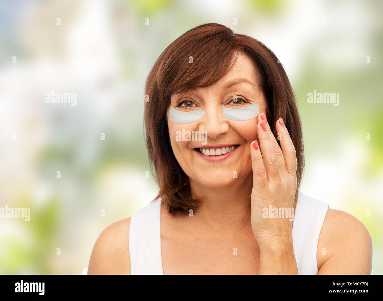 Gerne ältere Frau mit hydrogel unter den Augen von Patches Stockfoto