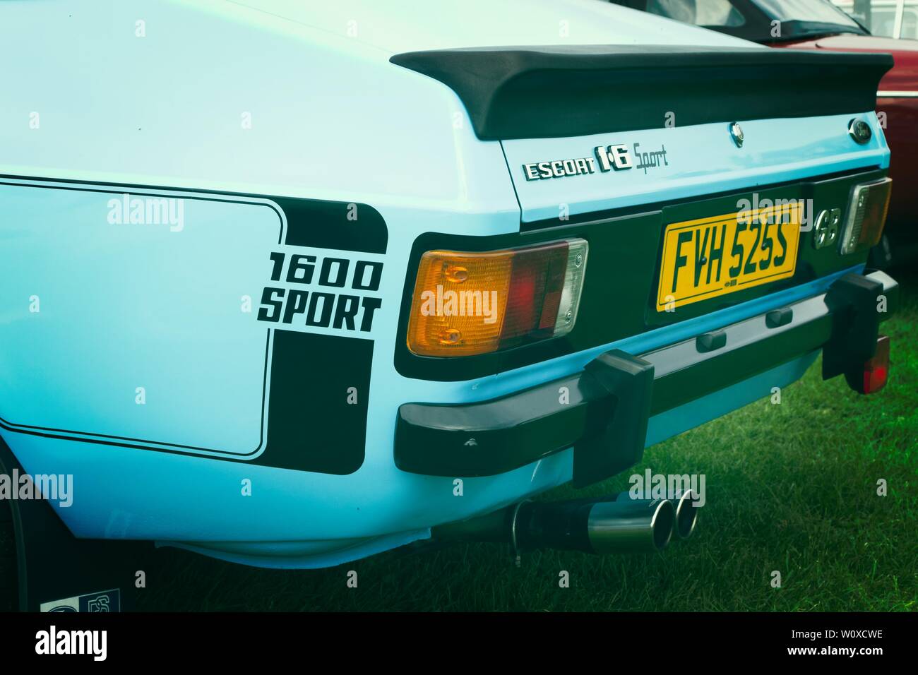 Split getonten Bild eines 1970er Ford Escort 1600 Sport mit blauer Lackierung mit schwarzen boot Spoiler, Stoßfänger und Aufkleber. Stockfoto