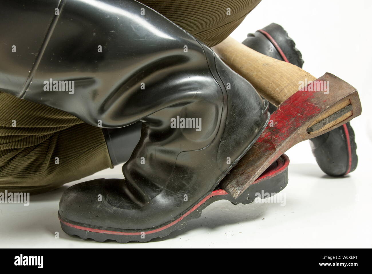 Hatte Luk. Eine Axt hat der Schuh Sohle der Sicherheit Gummistiefel eines Arbeitnehmers in zwei Hälften geteilt. Perspektive der schwarze Gummistiefel. Stockfoto