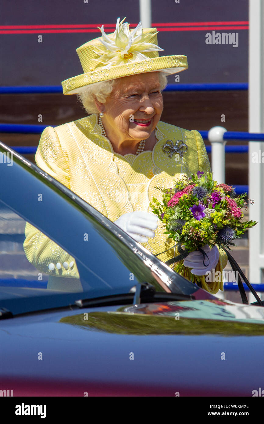 Ihre Majestät, Königin Elisabeth II. steht neben einem Auto halten sie Blumen bei Ihrer Ankunft an der Croy Bahnhof bei ihrem Besuch in Greenfaulds High School in Cumbernauld. Königin Elizabeth II. ist der Besuch Greenfaulds High School in Cumbernauld als Teil einer Woche der Royal Engagements über Schottland. Stockfoto