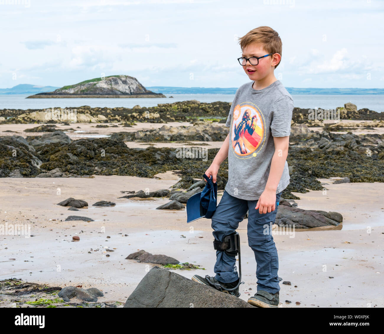8 Jahre alten behinderten Jungen mit zerebraler paslsy rechts Hemiplegie tragen Carbon turbo Bein am Strand strebe, East Lothian, Schottland, Großbritannien Stockfoto