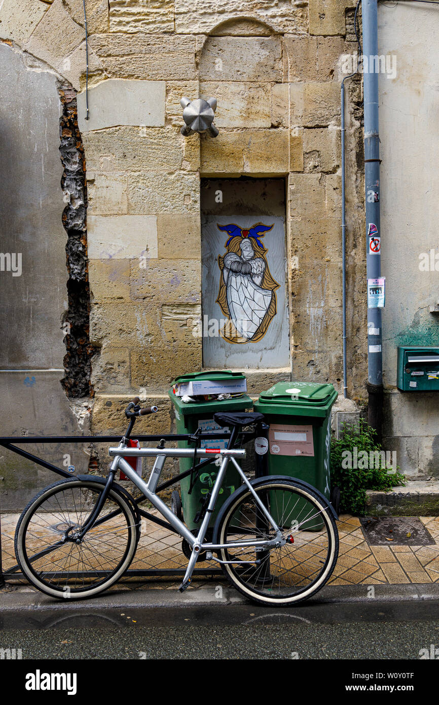 Street Art in einem Gebäude Alkoven mit Fahrrad und Papierkörbe, Bordeaux, Frankreich. Stockfoto