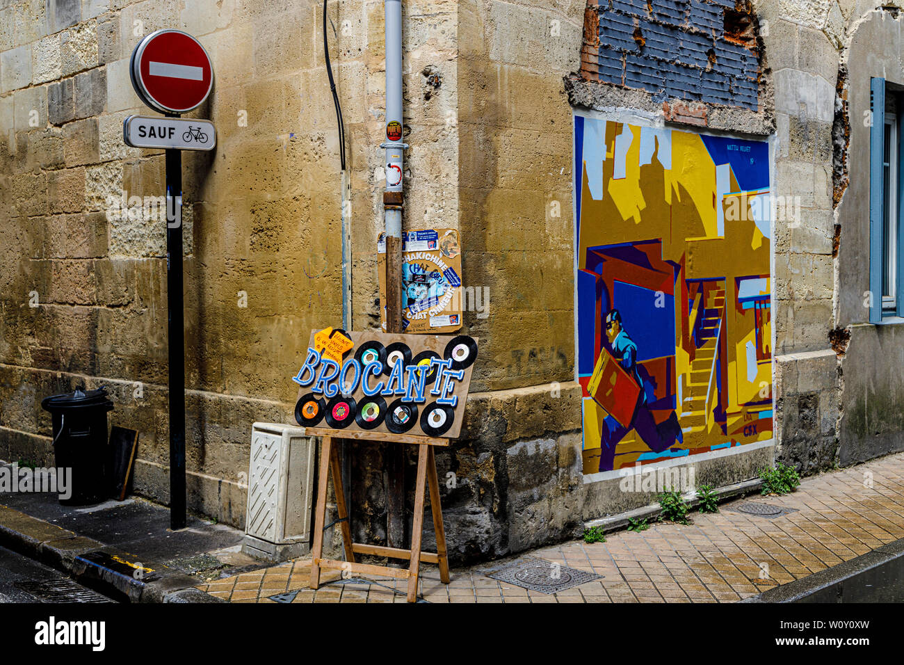 Straßenecke in Bordeaux, Frankreich. Zeichen, die keine Zufahrt nur für Fahrräder, Werbung für Shop Verkauf von Vinyl und einer Matth samt Wand Art. Stockfoto