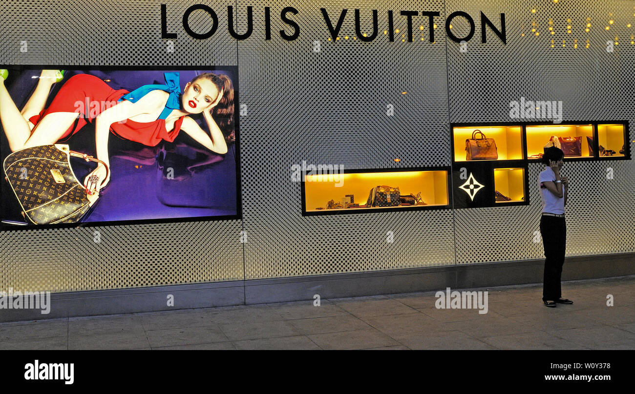 Kuala Lumpur - 2008.04.16: eine junge Frau mit ihrem Mobiltelefon stand vor einer Louis Vuitton Boutique an die Petronas Towers KLCC Shopping Mall Stockfoto