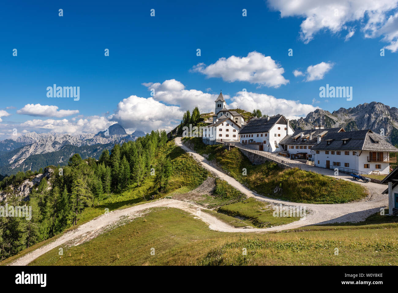 Dorf Monte Santo di Lussari (1790 m) und dem Gipfel des Mangart (2677 m.) in den Julischen Alpen. Tarvisio, Friaul Julisch Venetien, Italien, Europa Stockfoto