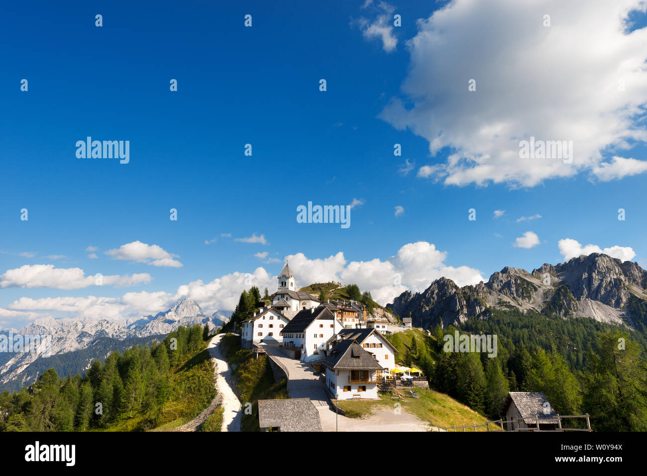 Alte Dorf Monte Santo di Lussari (1790 m) und dem Gipfel des Mangart in den Julischen Alpen. Tarvisio, Friaul Julisch Venetien, Italien, Europa Stockfoto