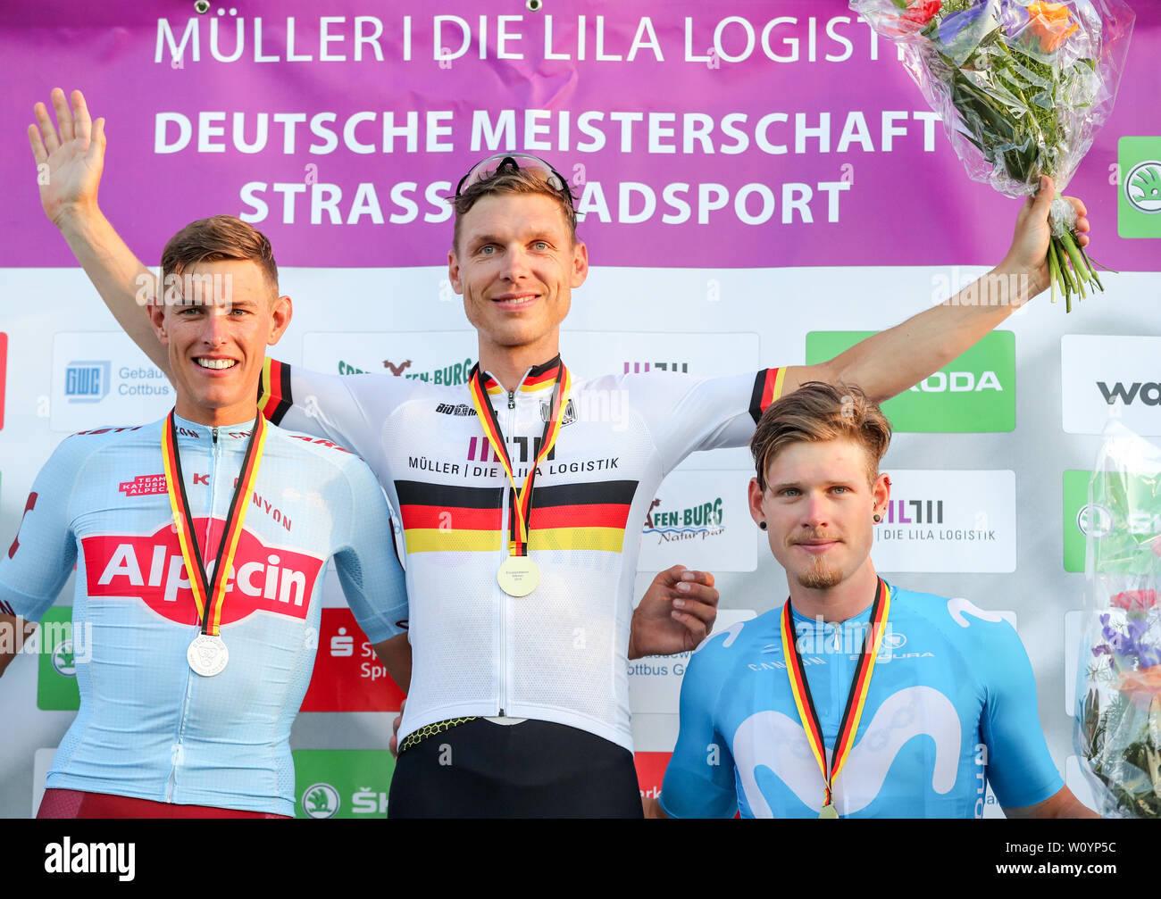 Spremberg, Deutschland. 28 Juni, 2019. Deutsche Meisterschaft Einzelzeitfahren, Männer: die Radfahrer Nils Pollit (l-r, Platz 2), Tony Martin (Platz 1) und Jasha Sütterlin sind auf dem Podium nach dem einzelzeitfahren der Männer. Trotz eines technischen Defekts Martin den Titel bei den Deutschen Straßen Rad WM im Einzelzeitfahren gewonnen. Kredite: Jan Woitas/dpa-Zentralbild/dpa/Alamy leben Nachrichten Stockfoto