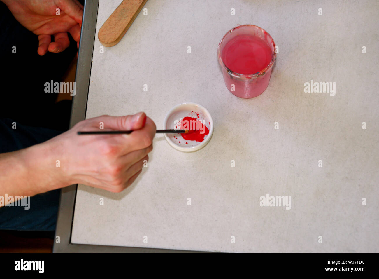 Mann Maler ist das Mischen von Farben vor dem malerei Kunst lack Studio. Künstler in seiner Hand hält Pinsel Farbe Ölfarben für Malerei auf der Palette gemischt. Stockfoto