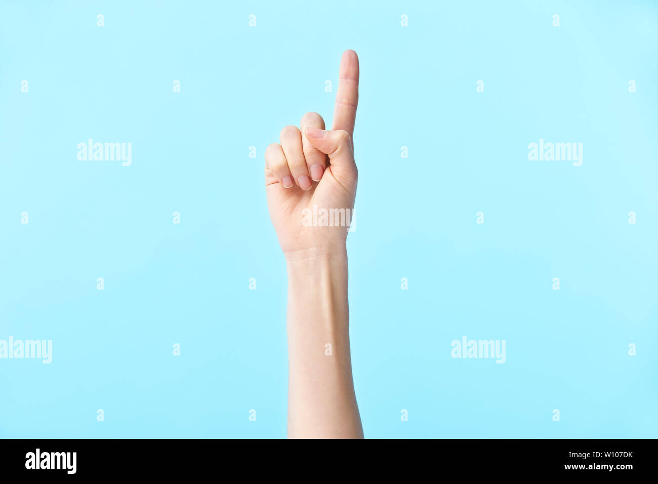 Menschliche Hand zeigt die Nummer eins, auf blauem Hintergrund isoliert Stockfoto