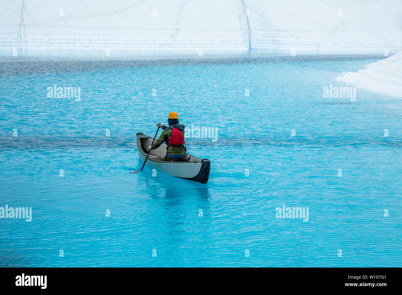 Alaska Mann auf einem Gletscher sein Kanu paddeln in einem Supraglazialen See oben auf dem Eis. Stockfoto
