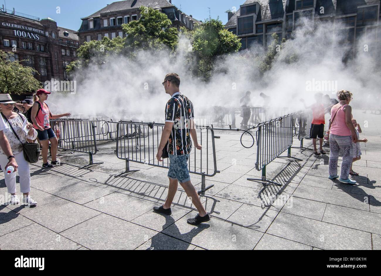 Straßburg, Frankreich. 28 Juni, 2019. Leute cool, sich an einen Zerstäuber in Straßburg, Frankreich, 28. Juni 2019. Temperaturen in Frankreich 45 Grad Celsius am Freitag zum ersten Mal seit dem Beginn der Temperaturmessungen, nach Meteo France. Wie die Hitzewelle einen außergewöhnlichen Spitzenwert von Wärme am Freitag erreicht, warnte Meteo France, viele absolute Temperatur Rekorde gebrochen werden könnte. Quelle: Martin Lelievre/Xinhua/Alamy leben Nachrichten Stockfoto