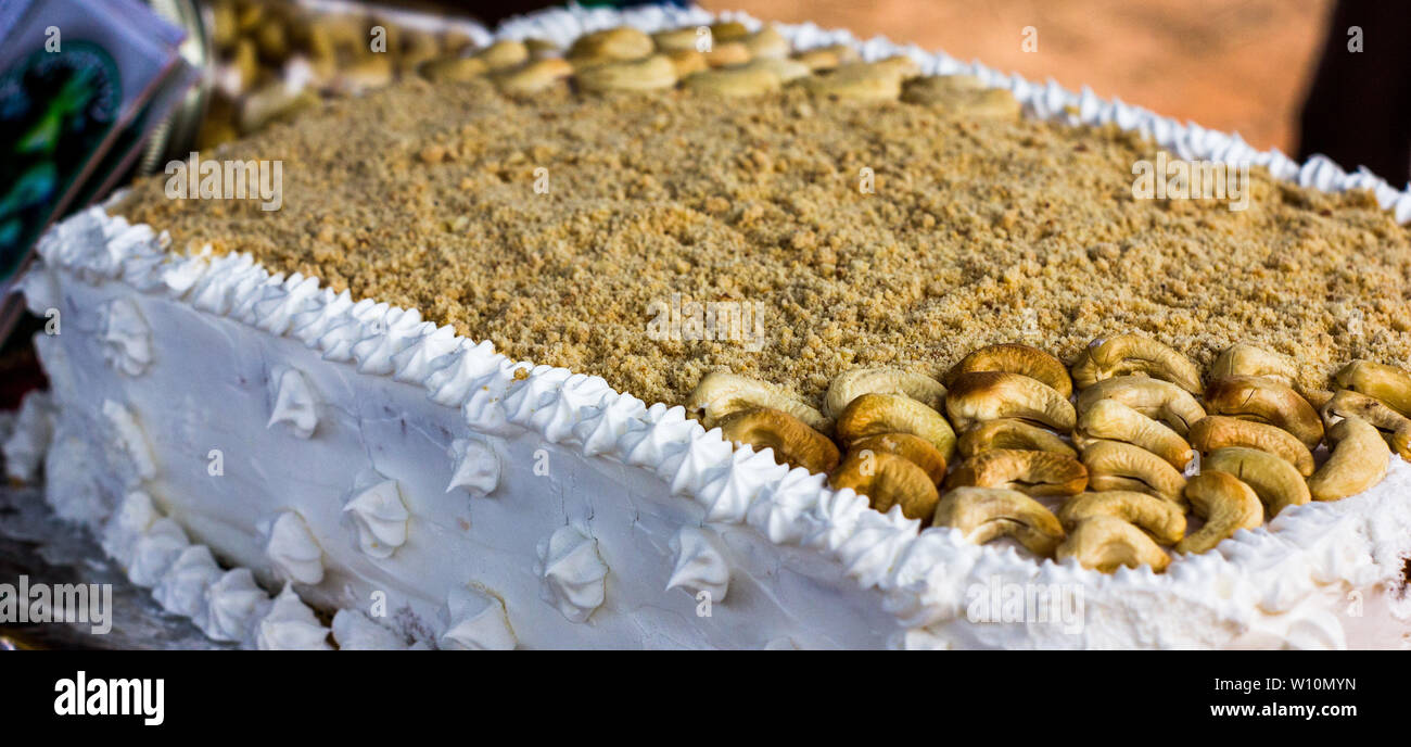 Cashewnuß-Kuchen mit zerquetschten Cashewnüsse und Zuckerguss Stockfoto