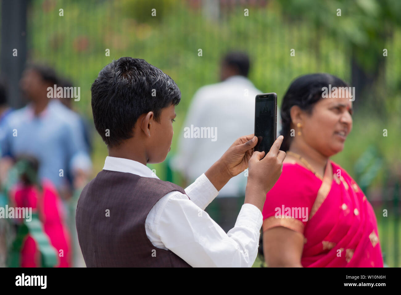 Bangalore, Karnataka India-June 04 2019: indischer Junge, ein Foto mit seinem Smartphone Vidhana Soudha Bengaluru versuchen. Kind mit Mobile Phon Stockfoto