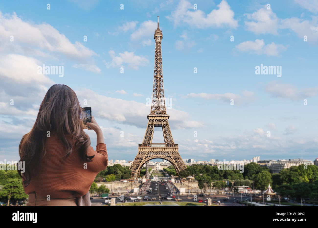 Reisende Frau unter Foto von Eiffel Turm, Wahrzeichen und Reiseziel in Paris, Frankreich durch Mobile Smartphone Stockfoto