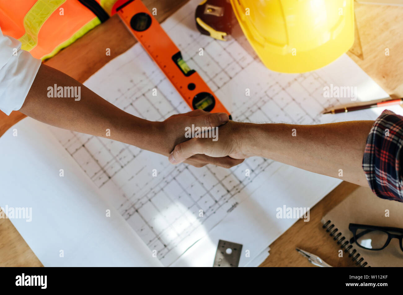 Ansicht von oben Bauarbeiter Team an die Hand schütteln Nach Vollendung bis business meeting Gruß starten Projekt Vertrag in Baustelle Stockfoto