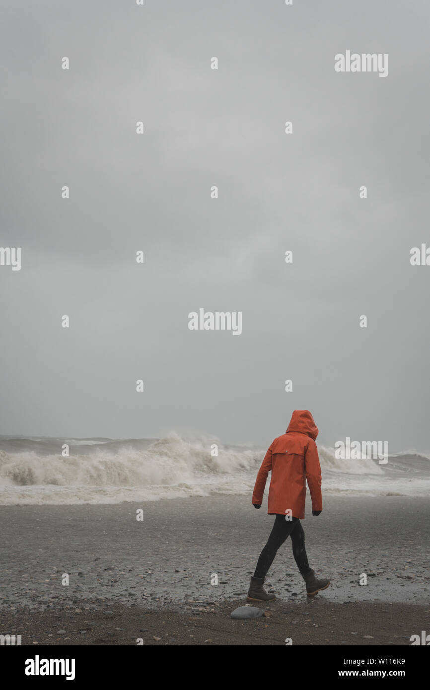 Orange Regenjacke gegen das Meer Stockfoto