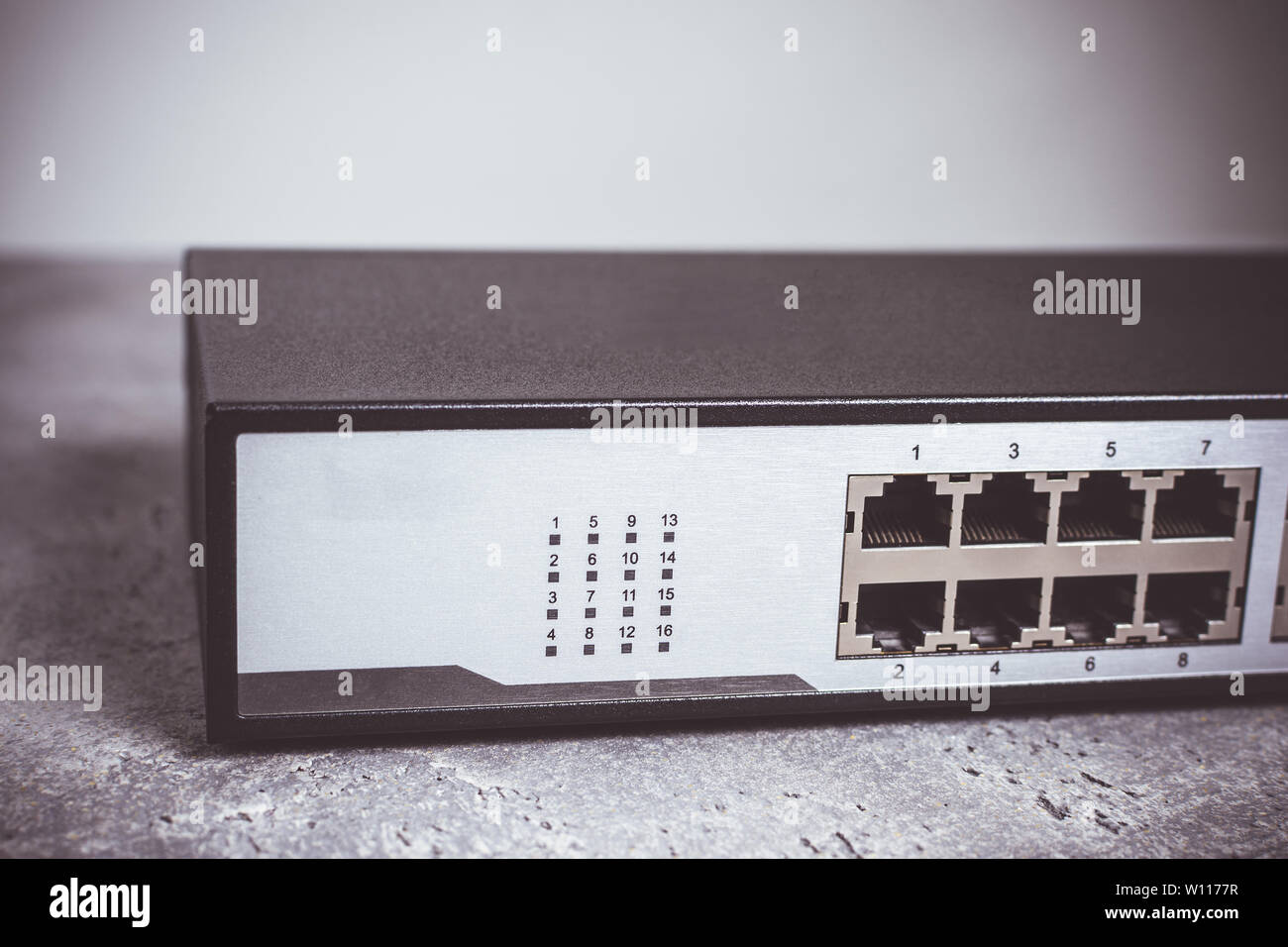 Schnelle Gigabit-Ethernet-Switch mit 16 Anschlüssen auf dunklem Hintergrund Stockfoto