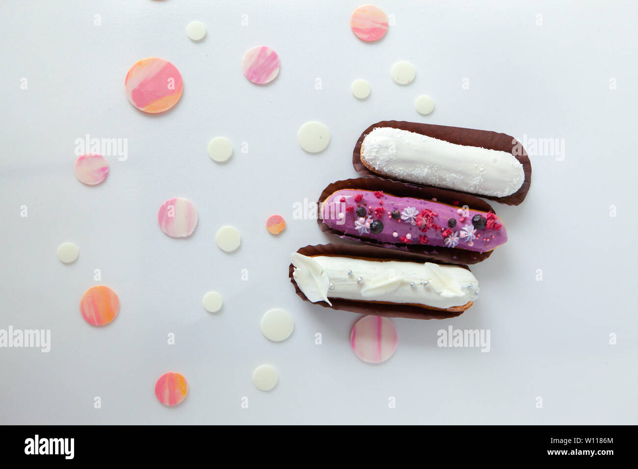 Ein Satz von drei eclairs mit verschiedenen Füllungen und Design auf ...