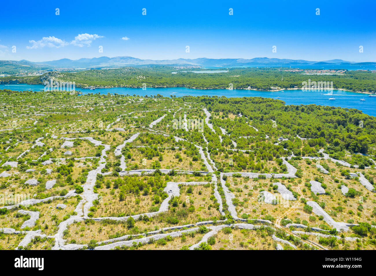 Kroatische Adriaküste, schöne Landschaft in Sibenik Kanal, alte Landwirtschaft Felder und Turquoise Bay mit Yachten und Boote, Luftaufnahme Stockfoto