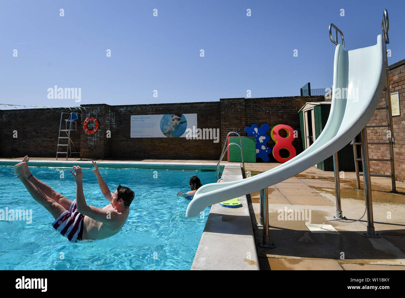 Ein Schwimmer verwendet die Folie am Lido in Chipping Norton, Oxfordshire, an dem Tag, an dem ein neuer Datensatz für einen Juni Temperatur in Großbritannien sehen konnte. Stockfoto