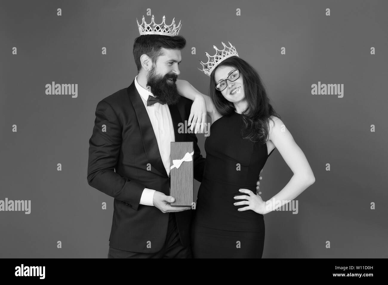 Royal Traditionen. Feiern Jubiläum. Royal Geschenk. König im Tuxedo goldene Krone, Geschenkbox Königin seines Herzens. Verliebtes Paar königliche Familie. Elite der Gesellschaft. König und Königin formale Veranstaltung. Stockfoto