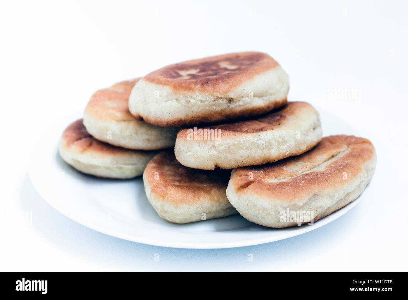 Gebratene Kuchen mit Kartoffeln und Bohnen auf weißem Hintergrund Stockfoto