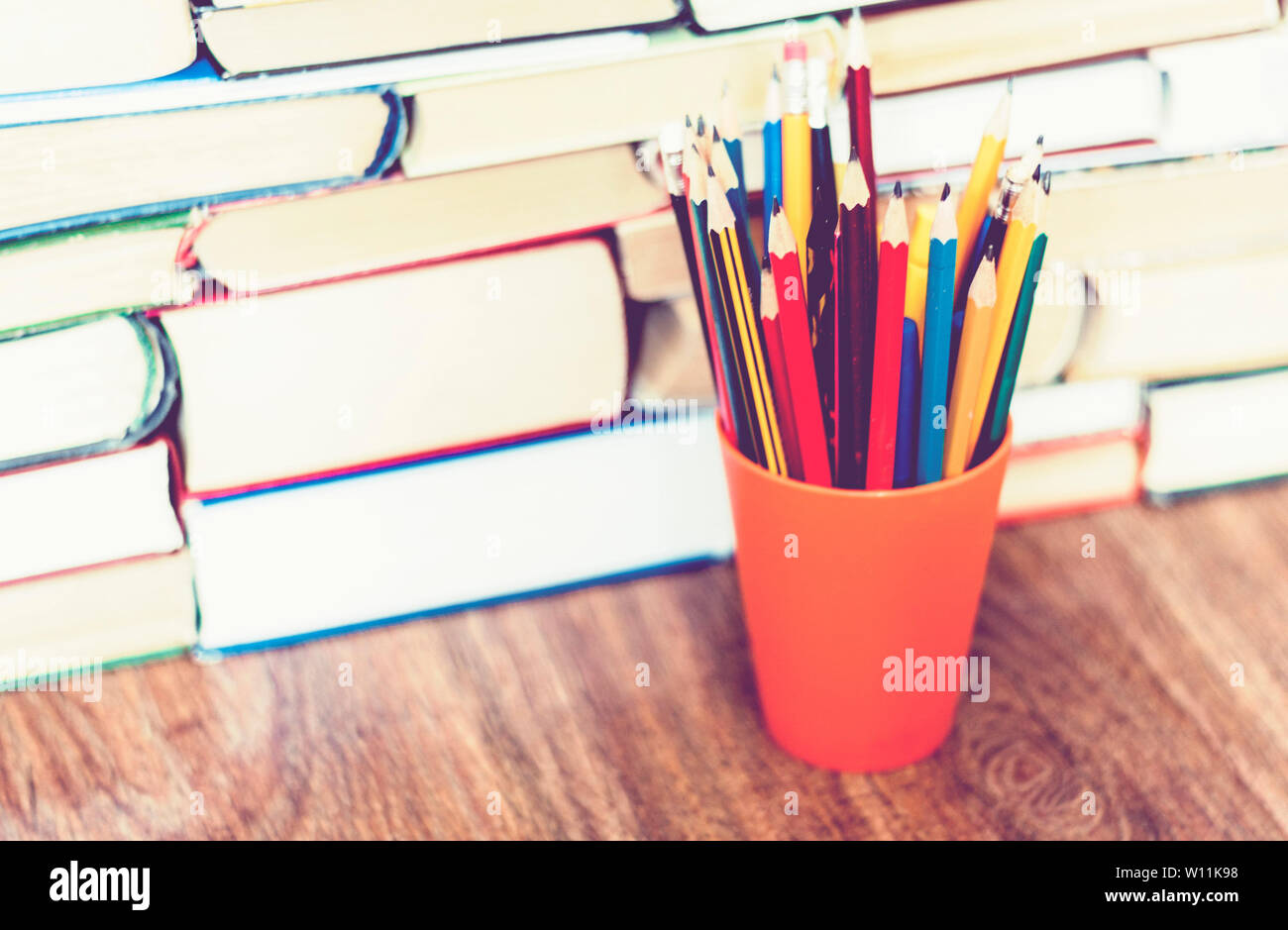 Buntstifte in Halter mit Stack von Buch Bildung Konzept Hintergrund Stockfoto