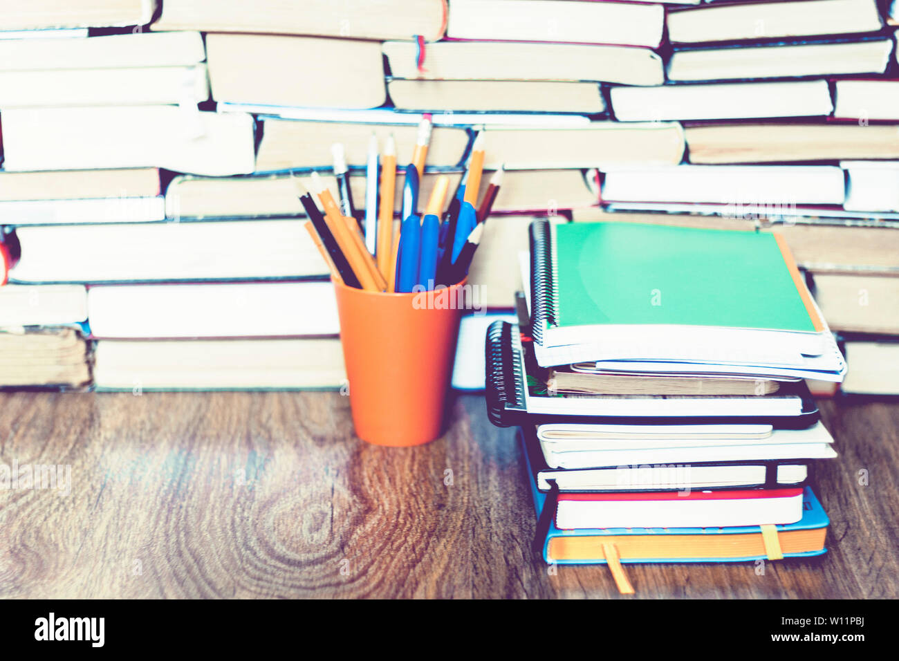 Buntstifte in Halter mit Stack von Notebooks auf Buch Bildung Konzept Hintergrund Stockfoto