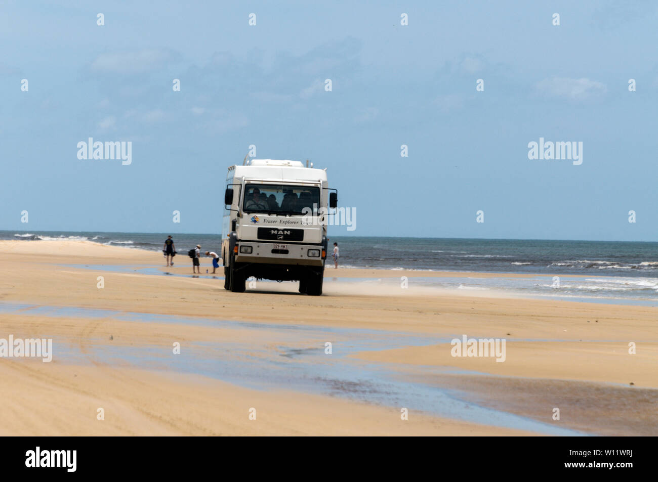 Ein tourist Tour Bus auf der zweispurigen Autobahn 75 km langen Sandstrand mit Blick auf die South Pacific Ocean auf Fraser Island in Queensland, Australien. Fraser Isla Stockfoto