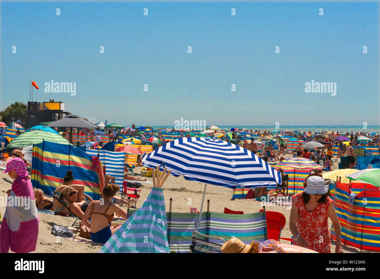 Der BRITISCHE Hitzewelle und der heisseste Tag des Jahres als Menschen zu überfüllten West Wittering Strand Schwarm im Solent, West Sussex zu kühlen. Hampshire England Stockfoto