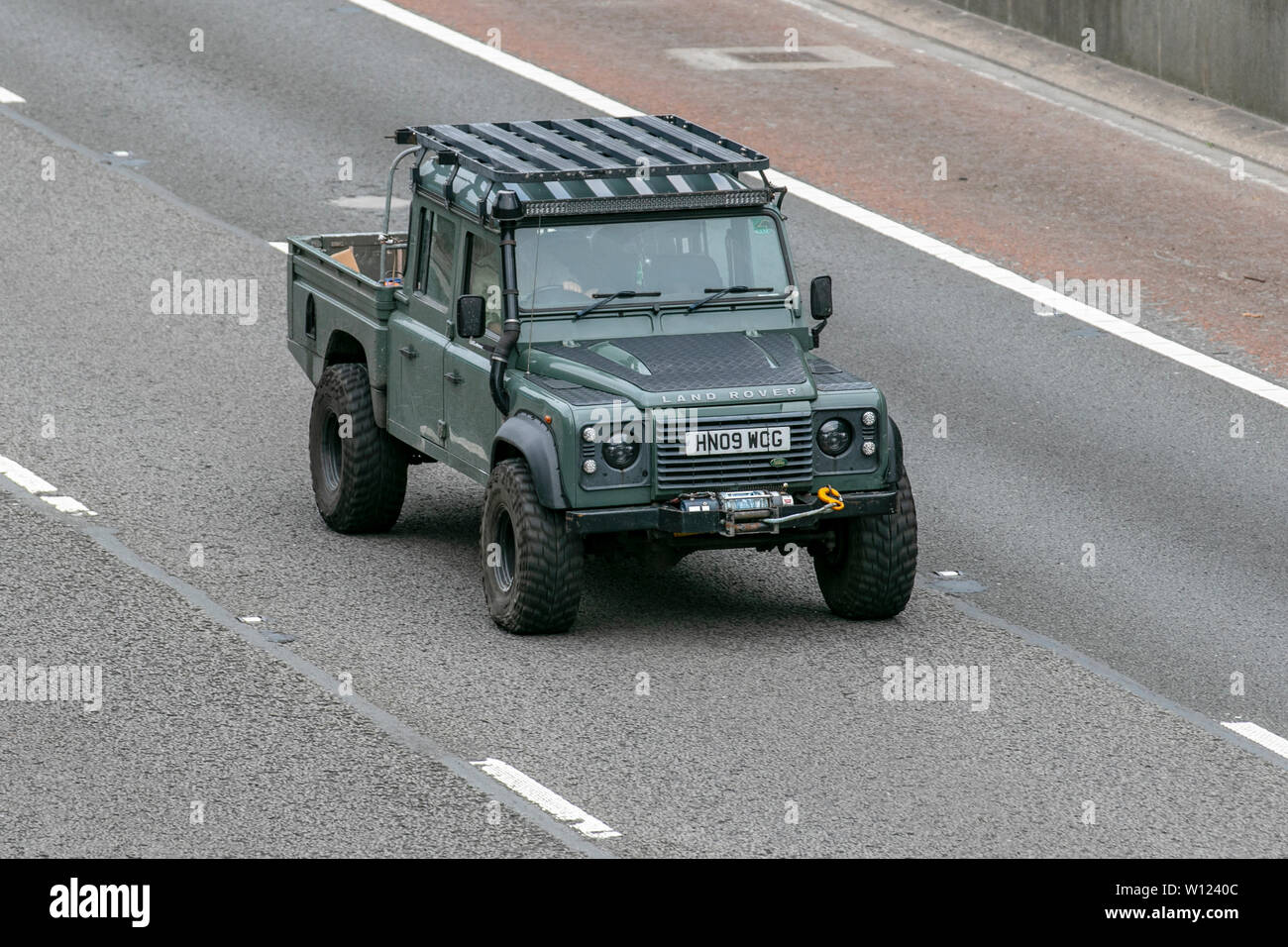 Green SWB 2009 Land Rover Defender 130 County HC D; mit Schnorchelauspuff, M6, Lancaster, Großbritannien; Fahrzeugverkehr, Transport, moderne, Salonwagen, in Richtung Norden auf der 3-spurigen Autobahn. Stockfoto