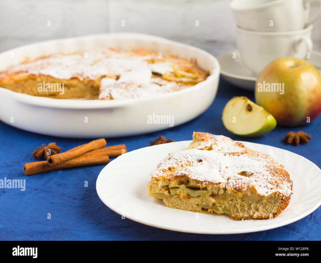 Traditionelle hausgemachte Apfelkuchen mit Zimt und Tee Utensilien auf dem Tisch Stockfoto