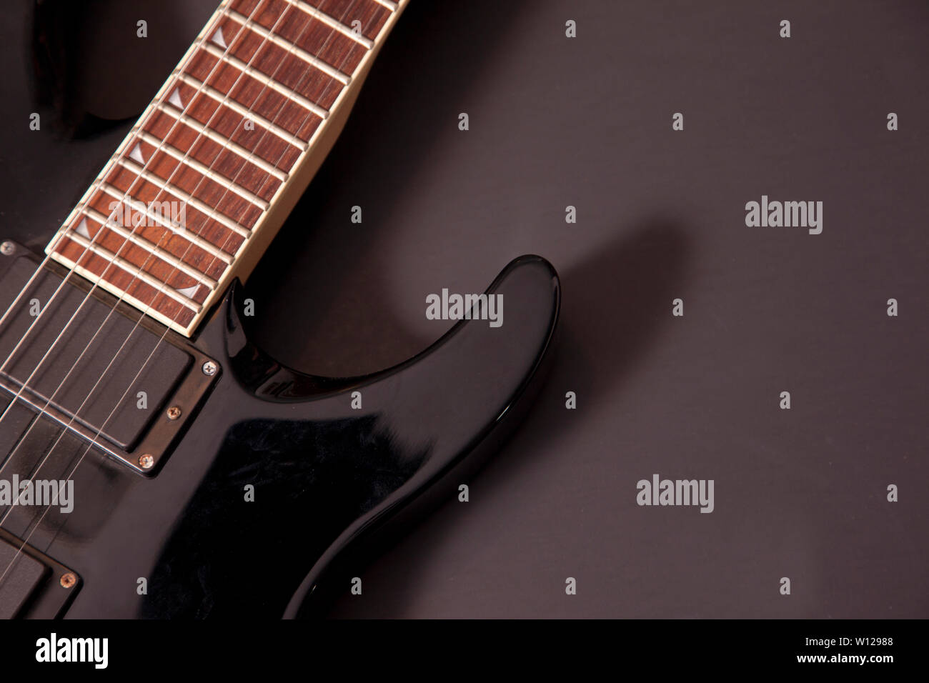Schwarzer Hintergrund mit einem schwarzen E-Gitarre Stockfoto