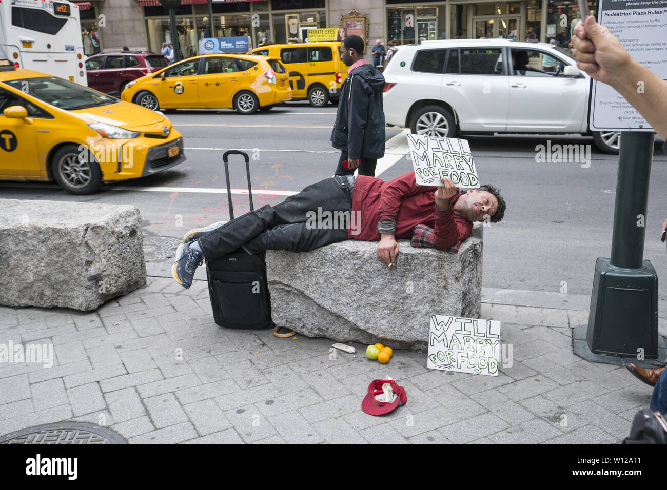 Obdachlosen mit einem Sinn für Humor bittet um Hilfe an der 42nd Street in Manhattan, New York City. Stockfoto