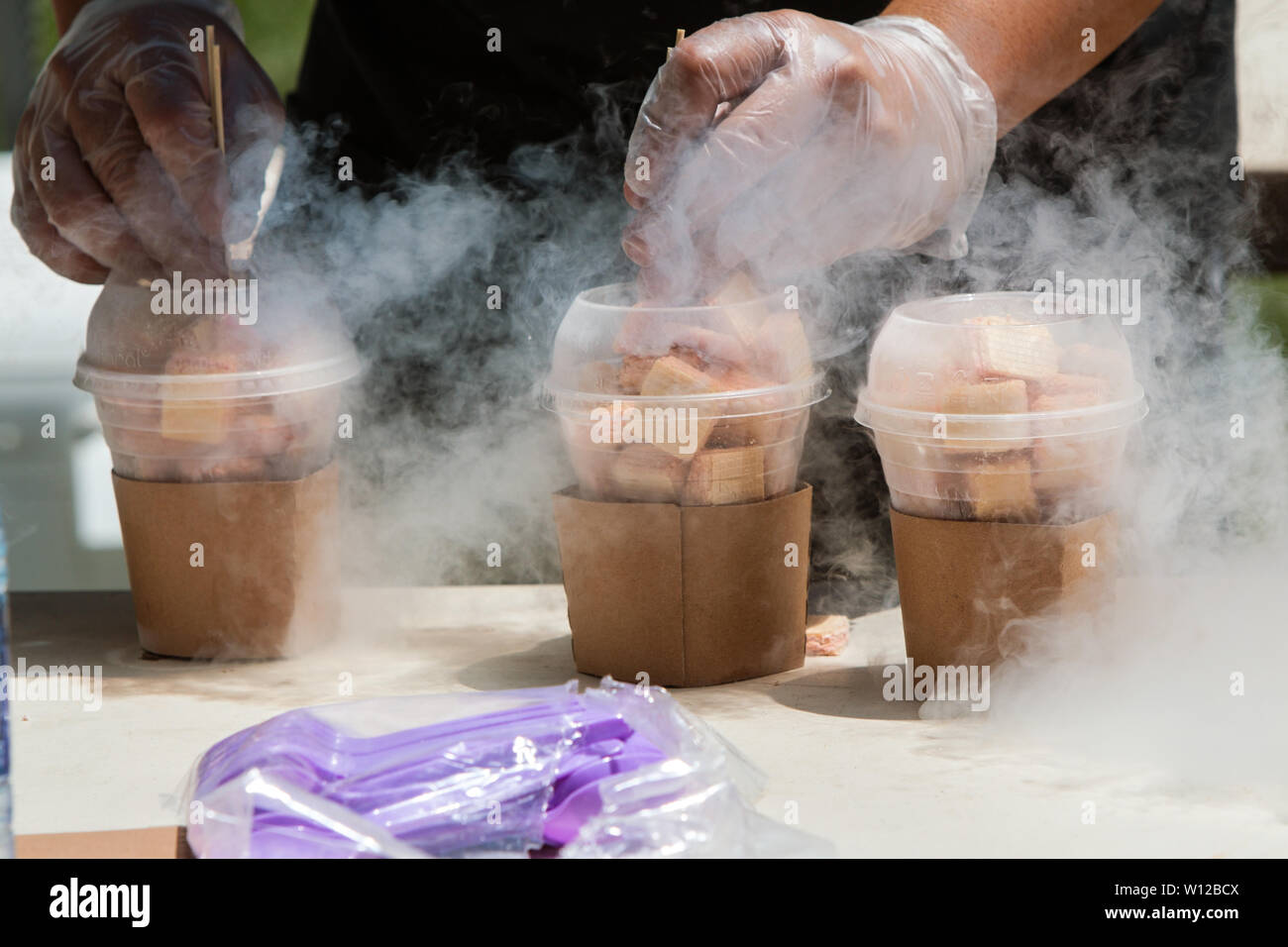 Des Menschen Hände bereiten gefrorenen Wüsten mit flüssigem Stickstoff bei Eis Festival. Stockfoto