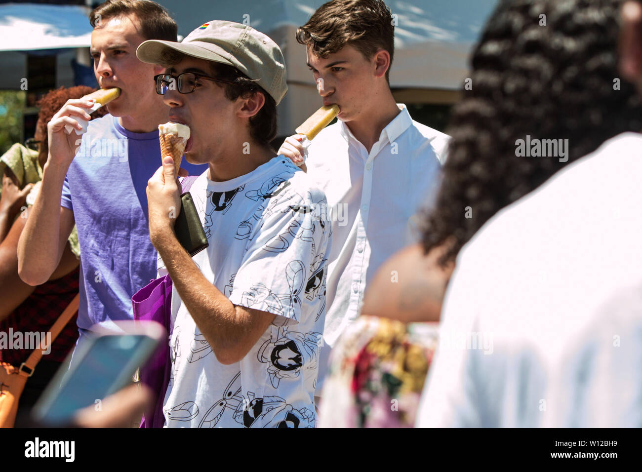 Junge Männer gehen und essen Eis an der Atlanta Eis Festival in Piedmont Park am Juli 28, 2018 in Atlanta, GA. Stockfoto