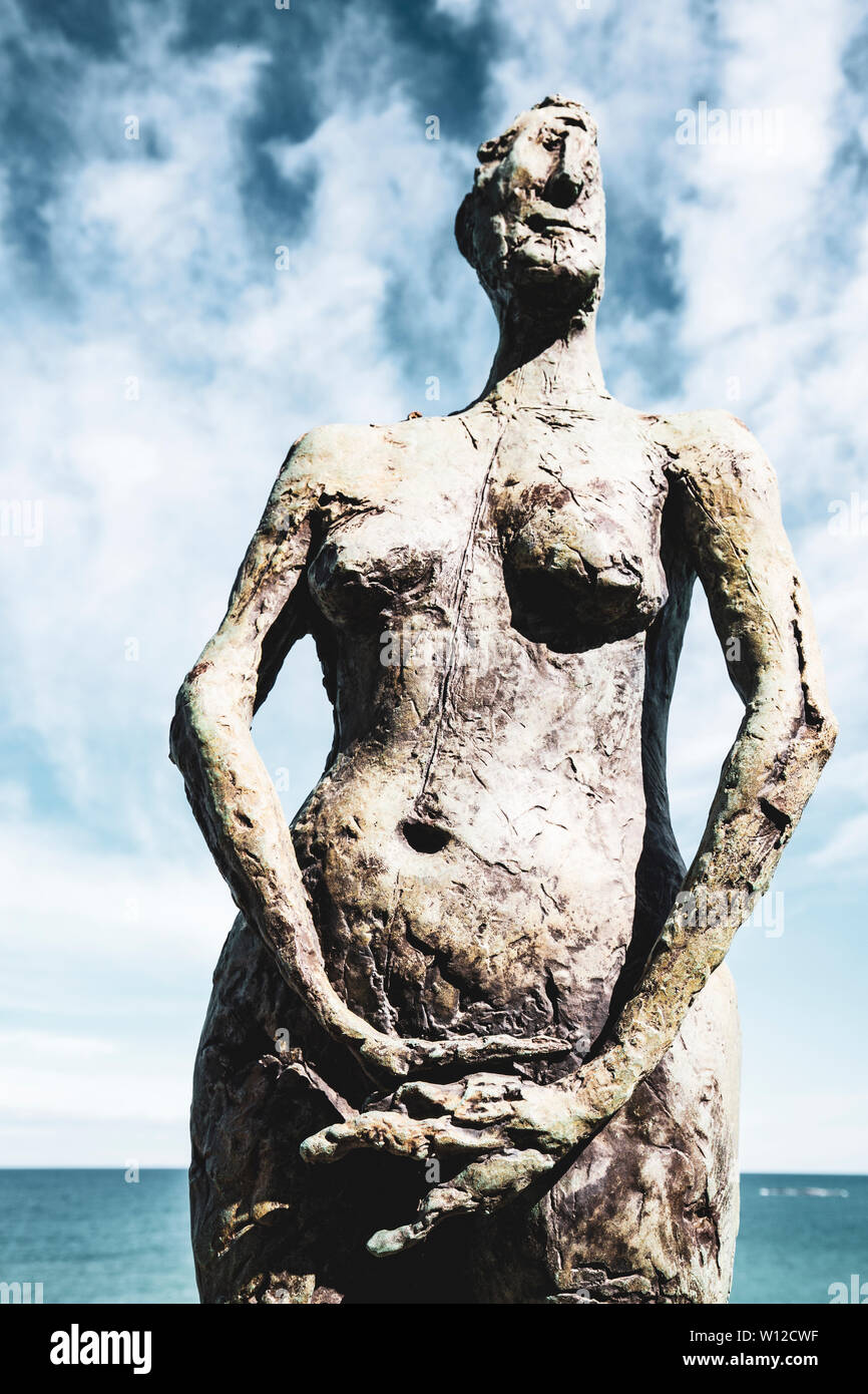 Stein Skulptur mit der menschlichen Form mit hinter einem bewölkten Himmel Stockfoto