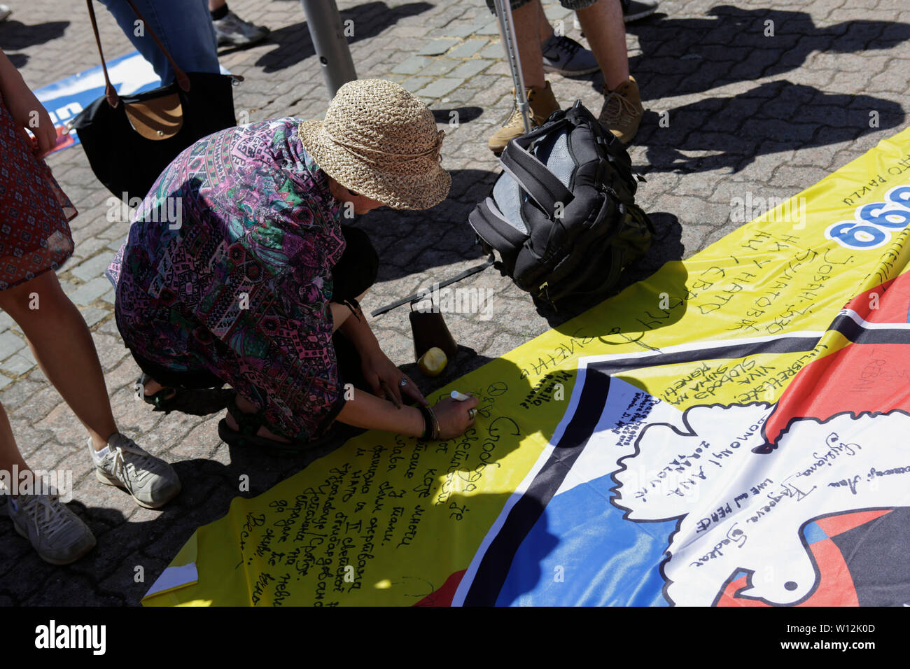 Ramstein, Deutschland. 29. Juni 2019. Eine Demonstrantin Zeichen seinen Namen auf einen Frieden Banner. ein paar tausend Friedensaktivisten aus dem Stopp der Air Base Ramstein Kampagne außerhalb der US-Airbase Ramstein protestiert. Der Protest war das Ende der diesjährigen Aktionswoche gegen die Airbase. Im Mittelpunkt der Veranstaltungen in diesem Jahr war die angebliche Beteiligung der Airbase in die drone Kriegsführung der US Air Force im Nahen Osten und in Afrika und Anruf Ramstein nicht für einen künftigen Krieg mit dem Iran. Stockfoto